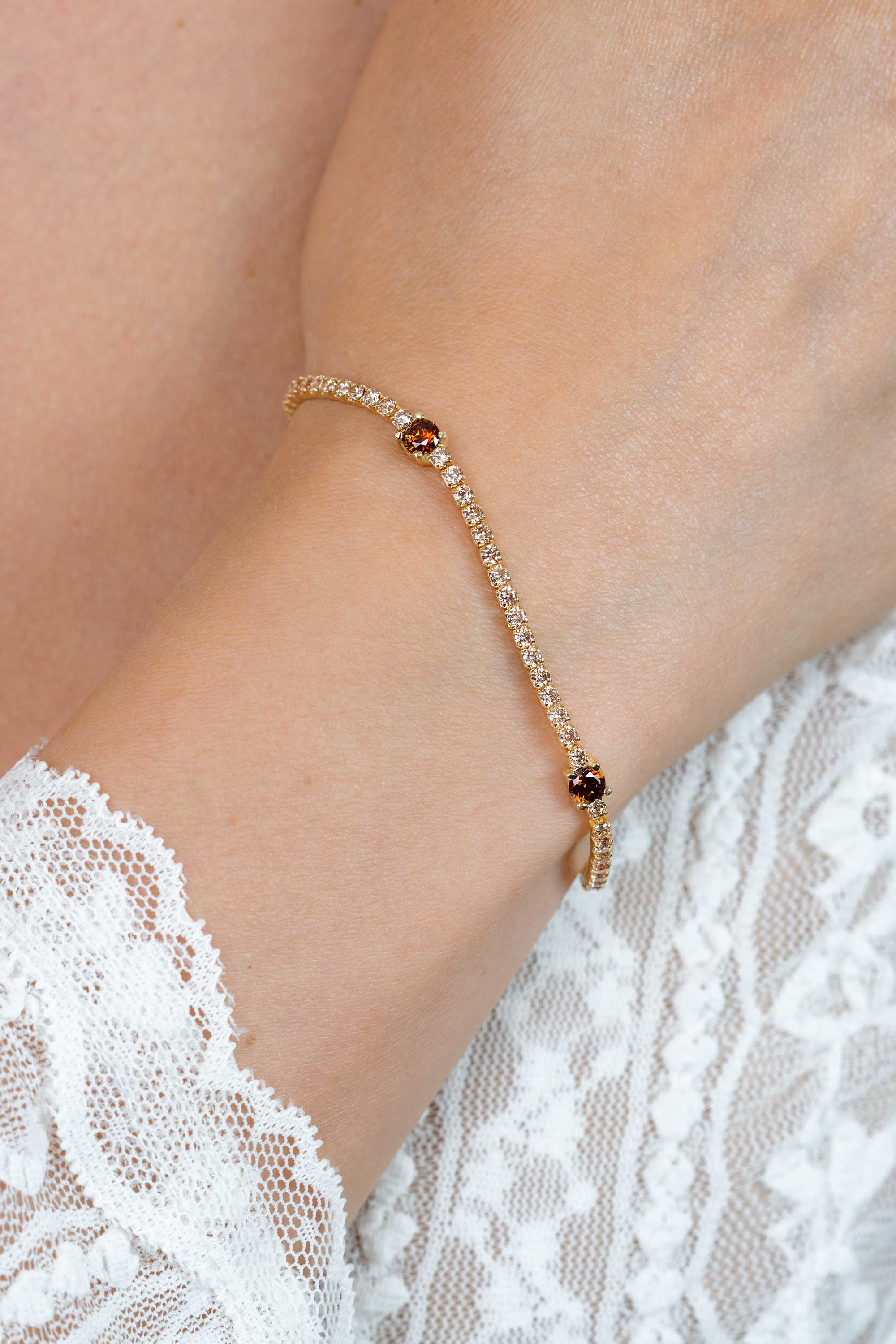 ZINZI gold plated zilveren tennisarmband 2,1mm breed bezet met champagnekleurige zirkonia’s in verfijnde rijzetting, afgewisseld met drie grotere donkerbruine kleurstenen (4,3mm) in chatonzetting ZIA2894C